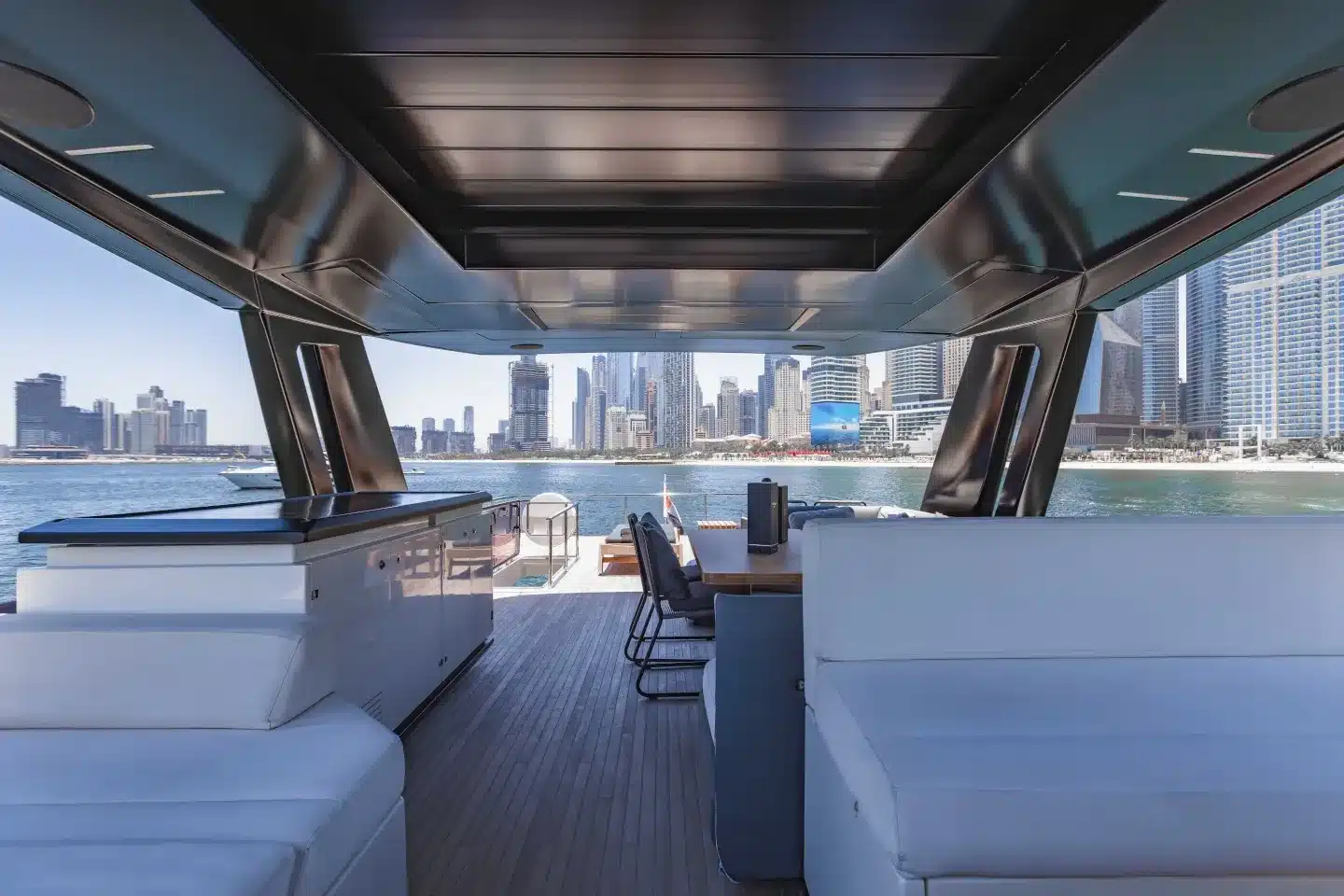 Ferretti 780 shaded flybridge dining and seating with the Dubai skyline