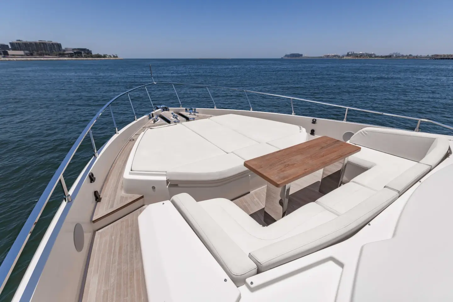 Ferretti 780 foredeck seating with folding teak table and sun pad