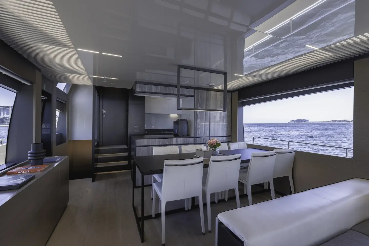 Ferretti 780 interior dining table with sea views through panoramic glazing