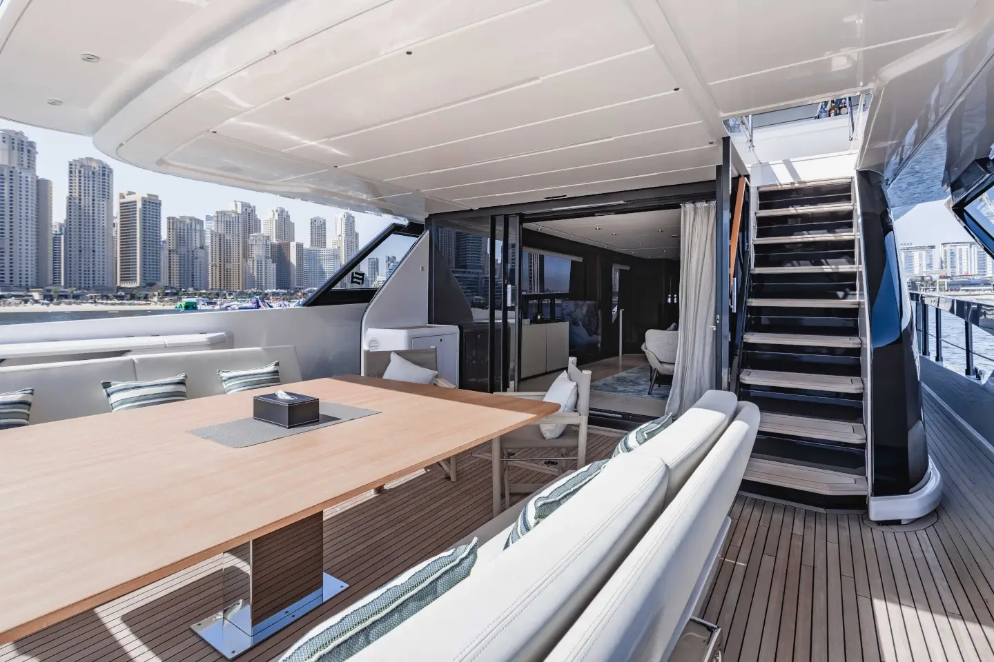 Ferretti 860 aft cockpit dining table with teak deck and flybridge stairs