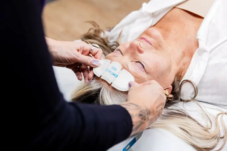 A shot of a provider placing Emface pads on a female patient for an alternative for Botox near Dublin, OH