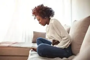 woman sitting and holding stomach