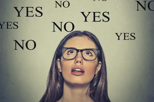 woman looking up with words "yes" and "no" floating around to symbolize choosing divorce mediation or litigation