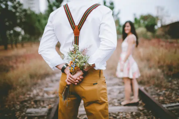 man holding flowers for woman symbolizing marriage in millennials