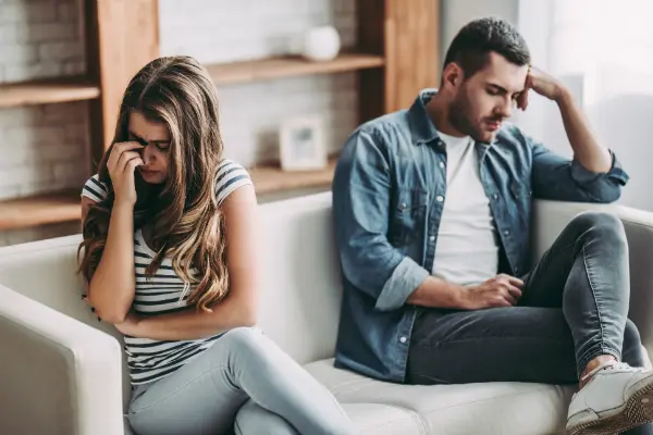 couple sitting on opposite ends of a couch symbolizing reasons for divorce