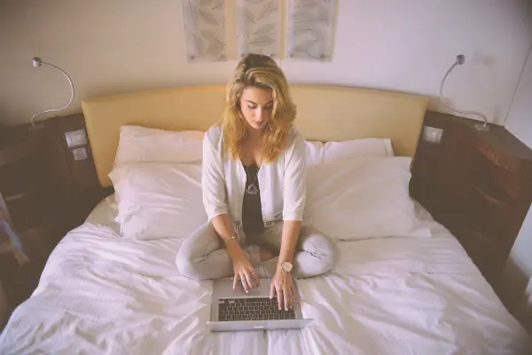 woman on laptop in bedroom symbolizing flirting online