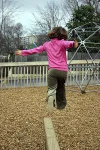 girl jumping on playground mulch