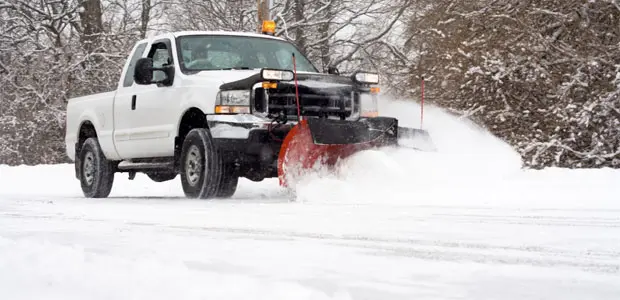 Plow truck clearing snow for property access