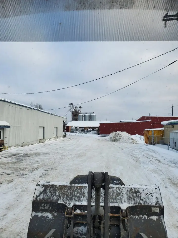 Snow-covered industrial yard with snow removal equipment