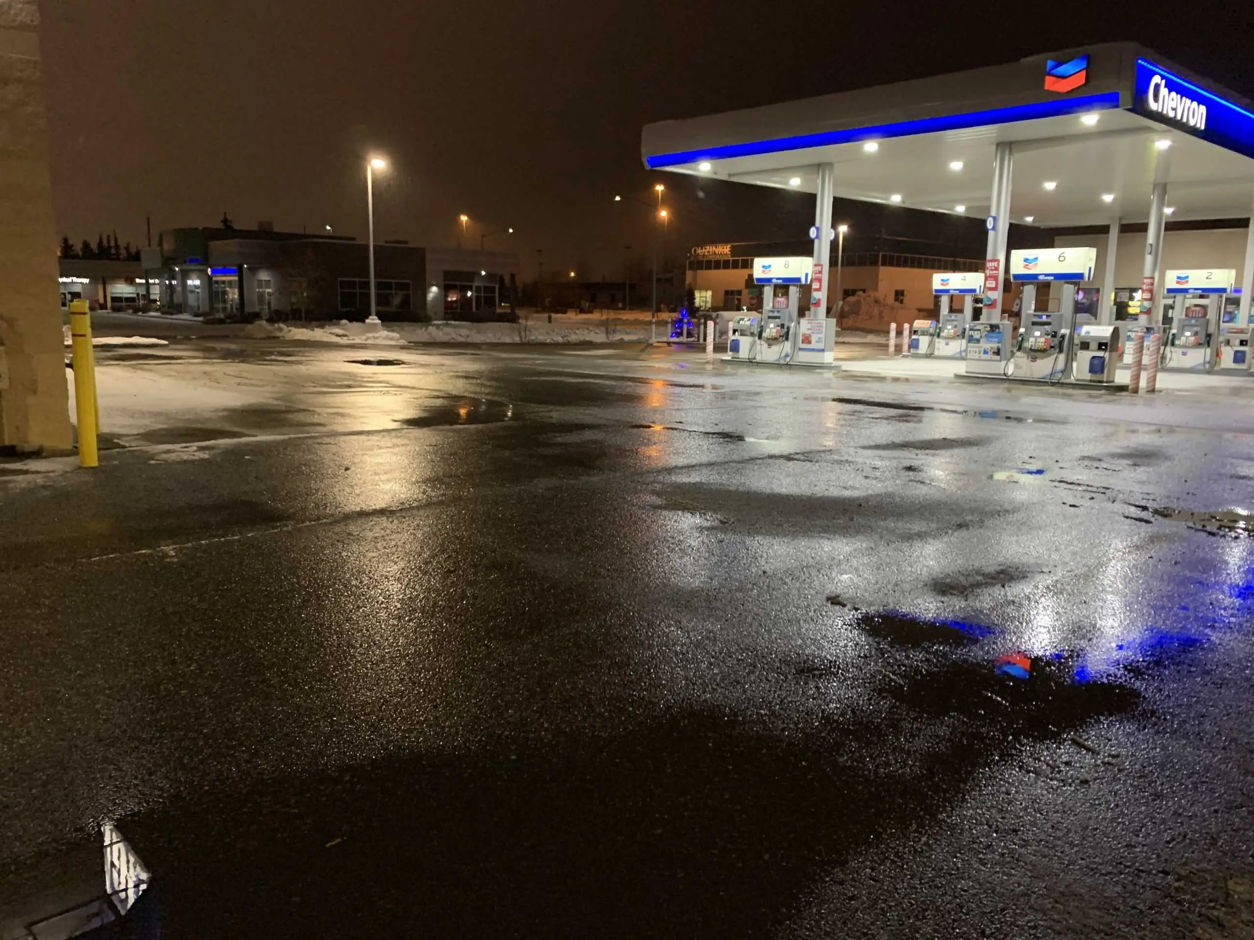 Commercial gas station lot plowed clear at night in Anchorage