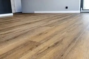 Modern vinyl panels imitating wood in the living room with selective focus and a shadow falling from the window.