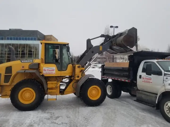 Loader filling a dump truck with snow for hauling off-site