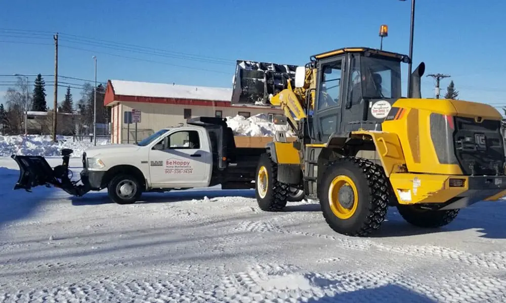 Snow removal crew with heavy equipment and pickup truck