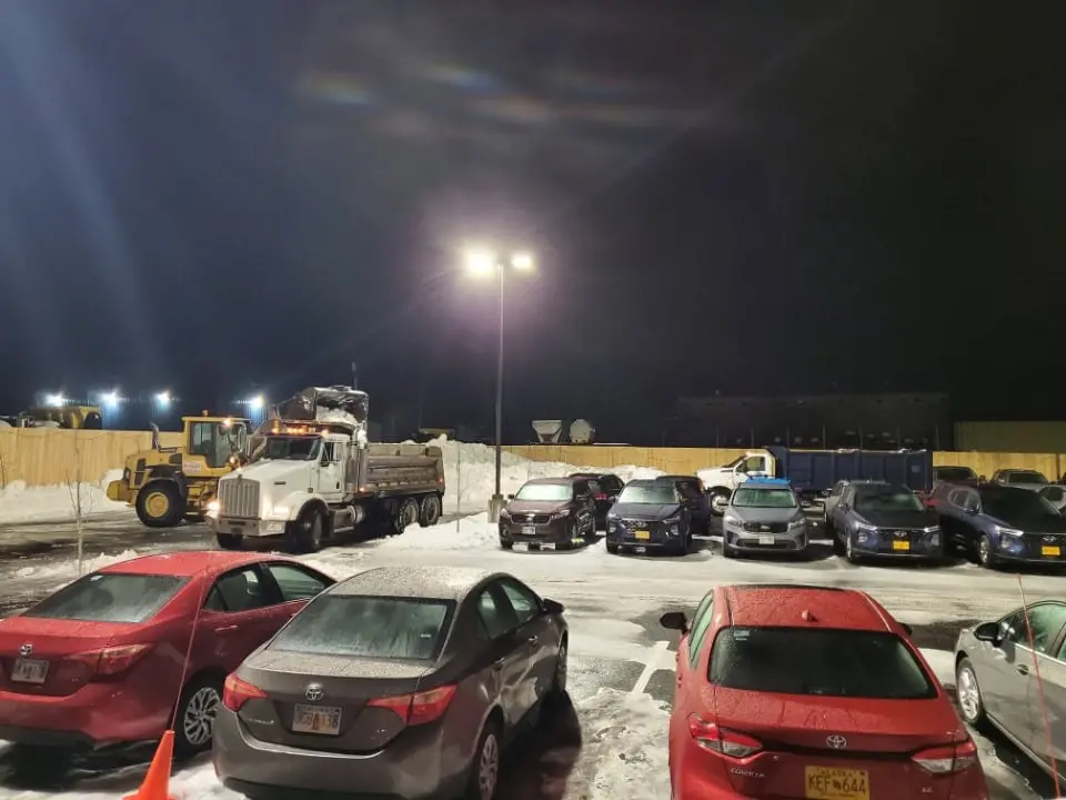 Night snow removal at a lighted parking lot