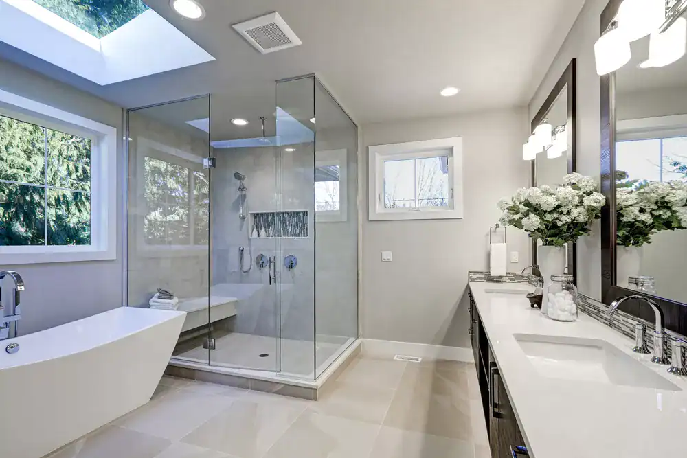 A modern bathroom with a glass shower, freestanding bathtub, and elegant vanity with floral decor.