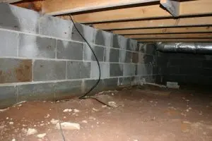 Waterproofed crawlspace with vapor barrier and drainage pipe, protecting against moisture damage and sagging floors.