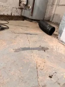Basement floor crack with sealant, indicating potential structural stress and water seepage.