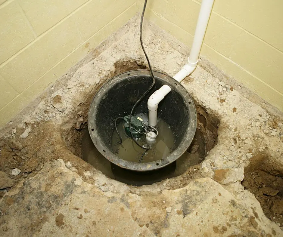 Sump pump running constantly inside a basement sump pit with standing groundwater and discharge piping during waterproofing system inspection.