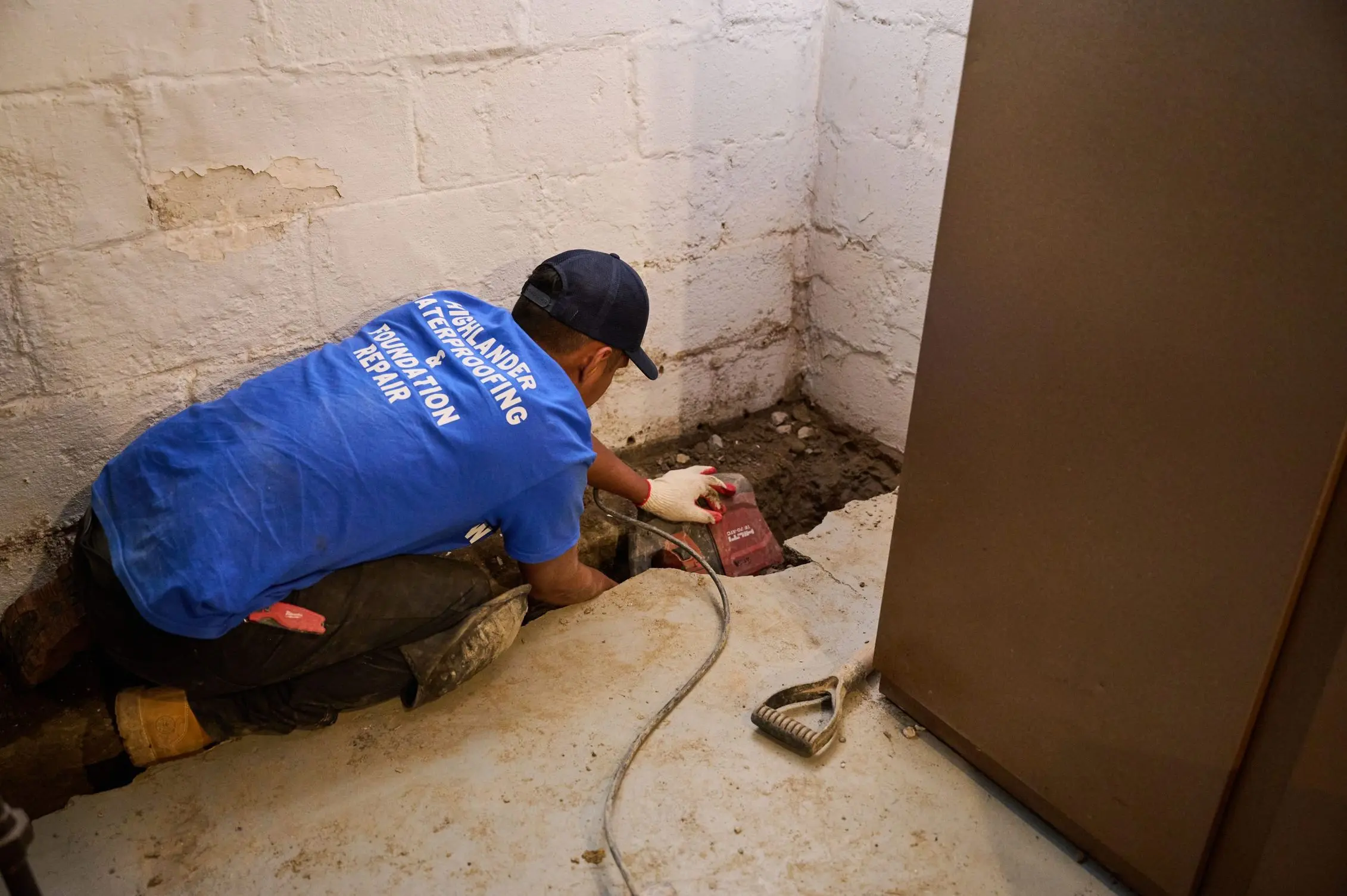 Highlander Waterproofing technician repairing basement floor seepage and water intrusion.