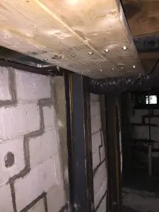 Steel I-beam installation for foundation stabilization and repair.