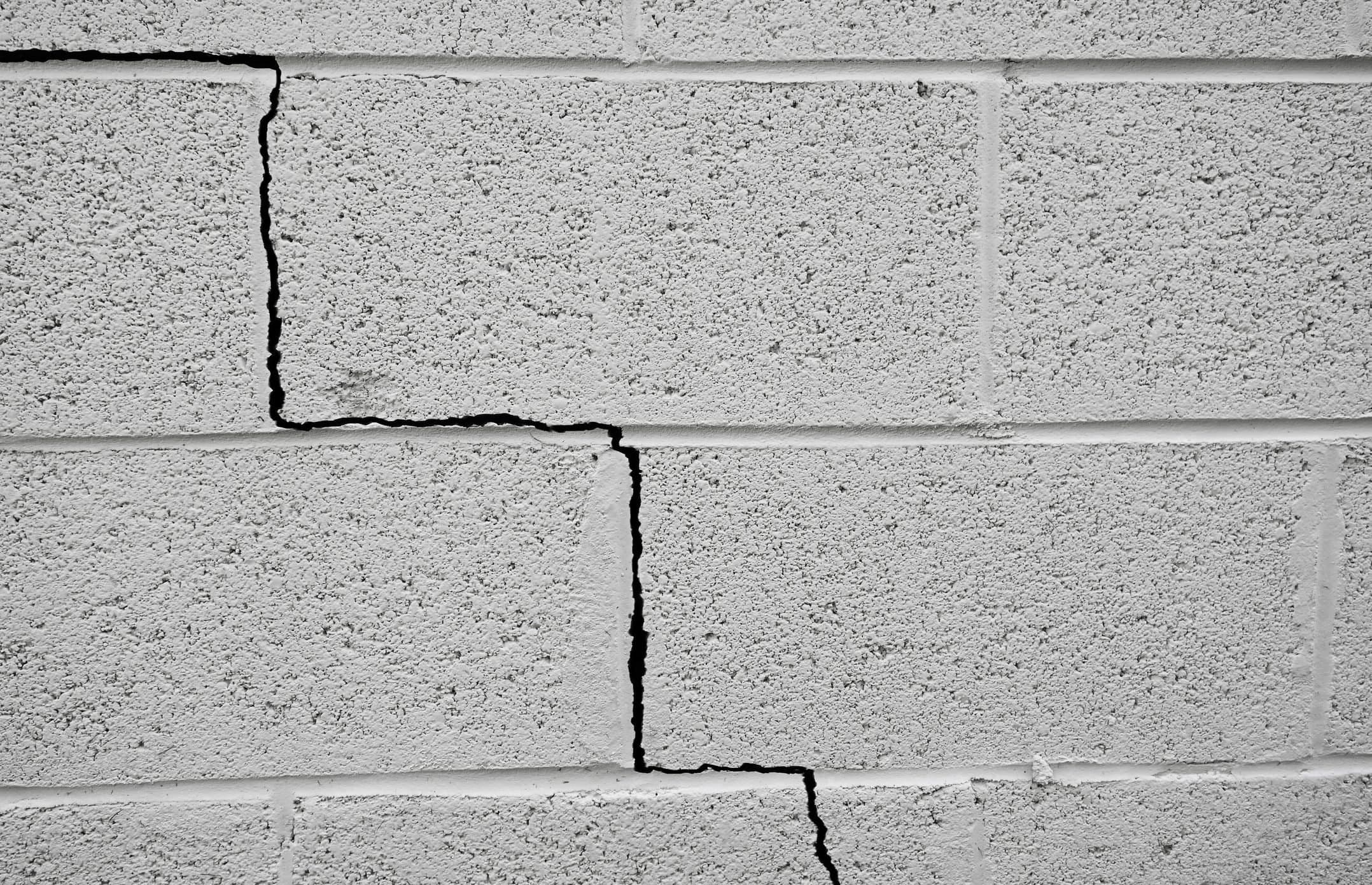 Stair-step crack in a concrete block wall showing signs of foundation settlement in Harrisburg, PA