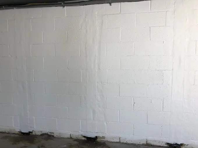 Freshly waterproofed basement wall with interior drainage system installed in a Pittsburgh home.