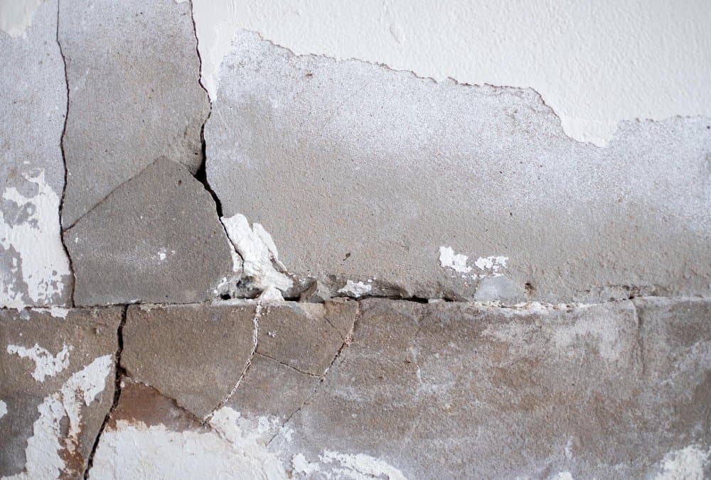 Cracked and damaged basement wall highlighting the need for foundation repair and waterproofing solutions.