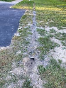 French drain installation in yard managing surface water and protecting foundation.