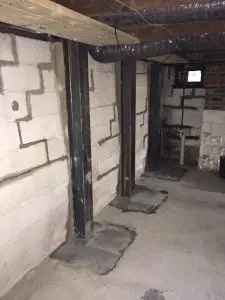 Steel beams reinforcing a basement foundation wall, structural stabilization for waterproofing.