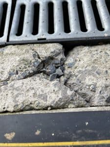 Damaged concrete foundation and drain tile system illustrating potential repair needs.