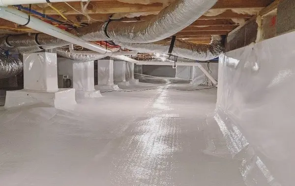 Professionally encapsulated crawlspace with white vapor barrier covering floors, walls, and support columns