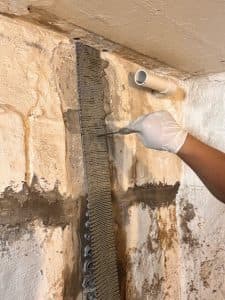 Foundation crack repair with epoxy injection and mesh reinforcement.