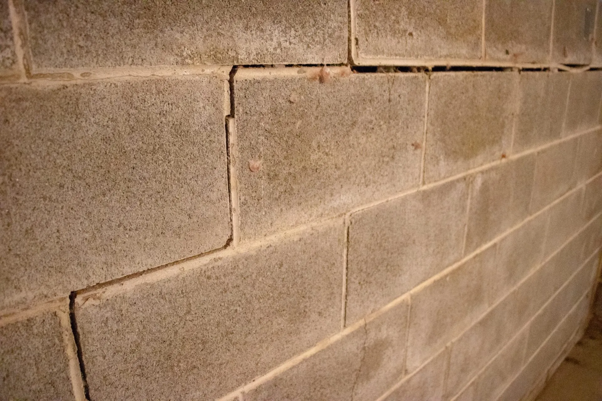 Bowing basement wall showing a horizontal crack and inward movement requiring professional bowing basement wall repair.