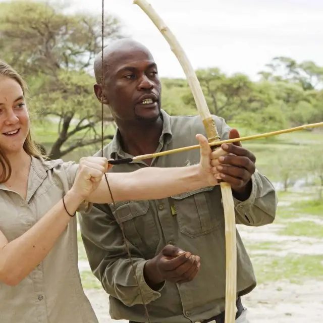 girl learning to shoot a bow and arrow