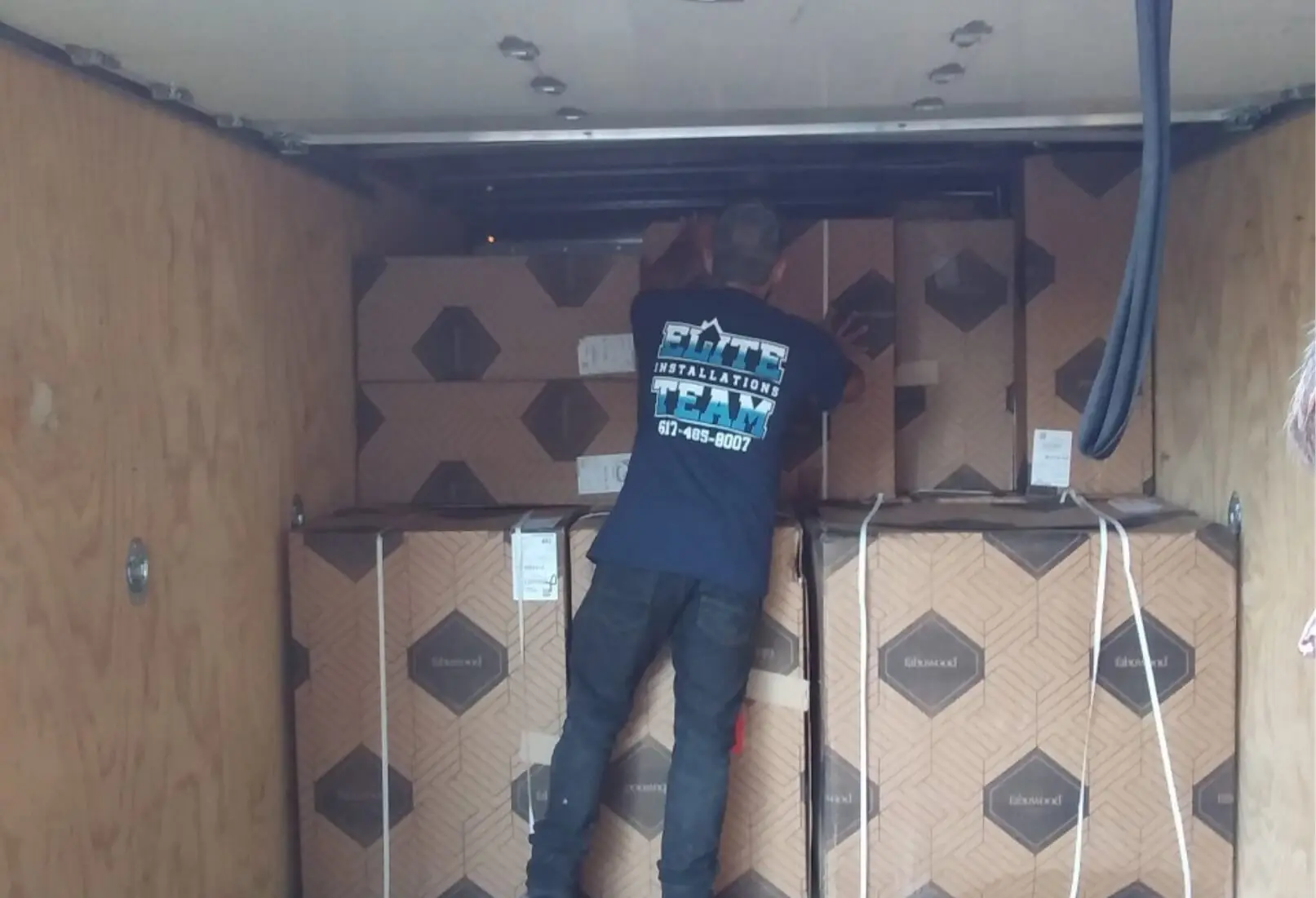a man standing on a truck with boxes in the back