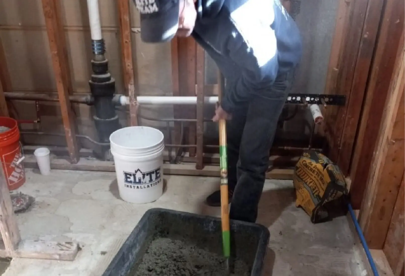 a man using a shovel to mix cement