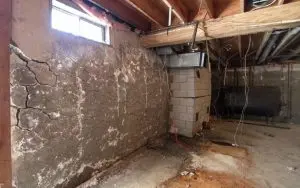 Basement wall with severe cracking and deterioration indicating possible need for foundation piering repair