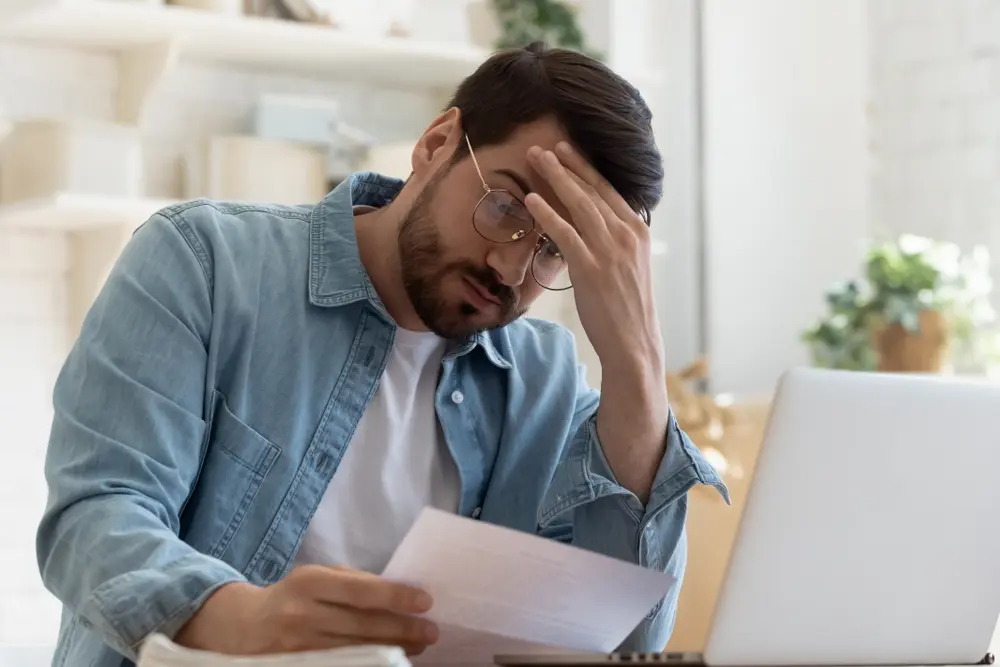 man at computer looking at numbers, concerned about a commercial property foreclosure