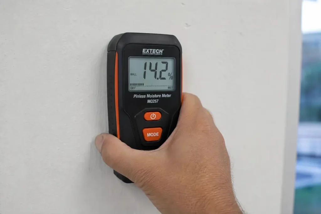 Pinless capacitance moisture meter reading on wall in Louisville KY