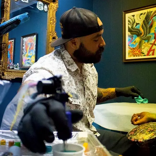 Tattoo artist working on a client at Dandyland Custom Tattoo San Antonio studio