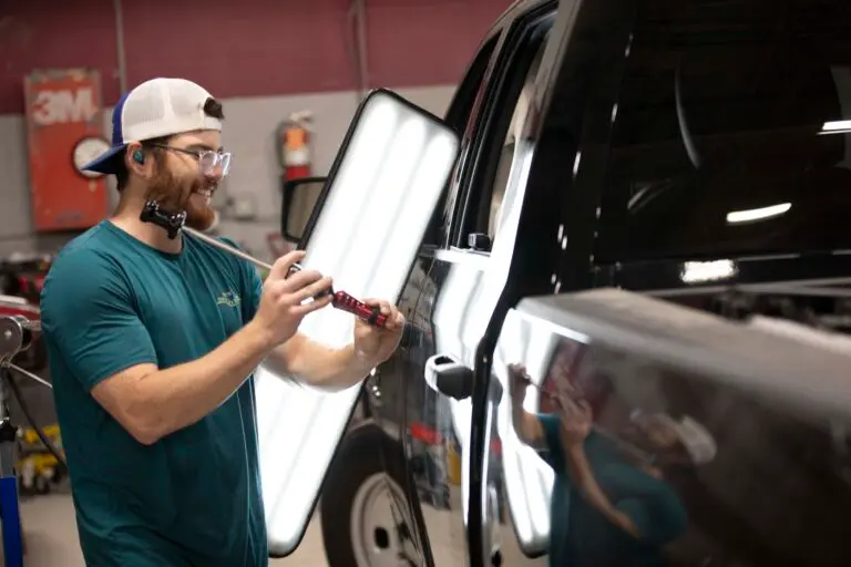 A technician uses a dent-repair tool during paintless dent repair at Collision Center 1 in Minnesota.