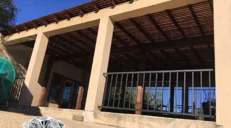 Stucco covered patio with stained wood slat ceiling and railing by Diamond Decks, San Antonio TX