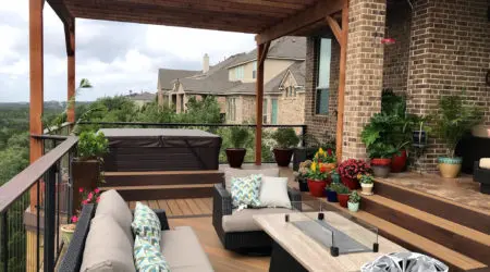 Attached cedar pergola over composite deck with fire table by Diamond Decks, San Antonio TX