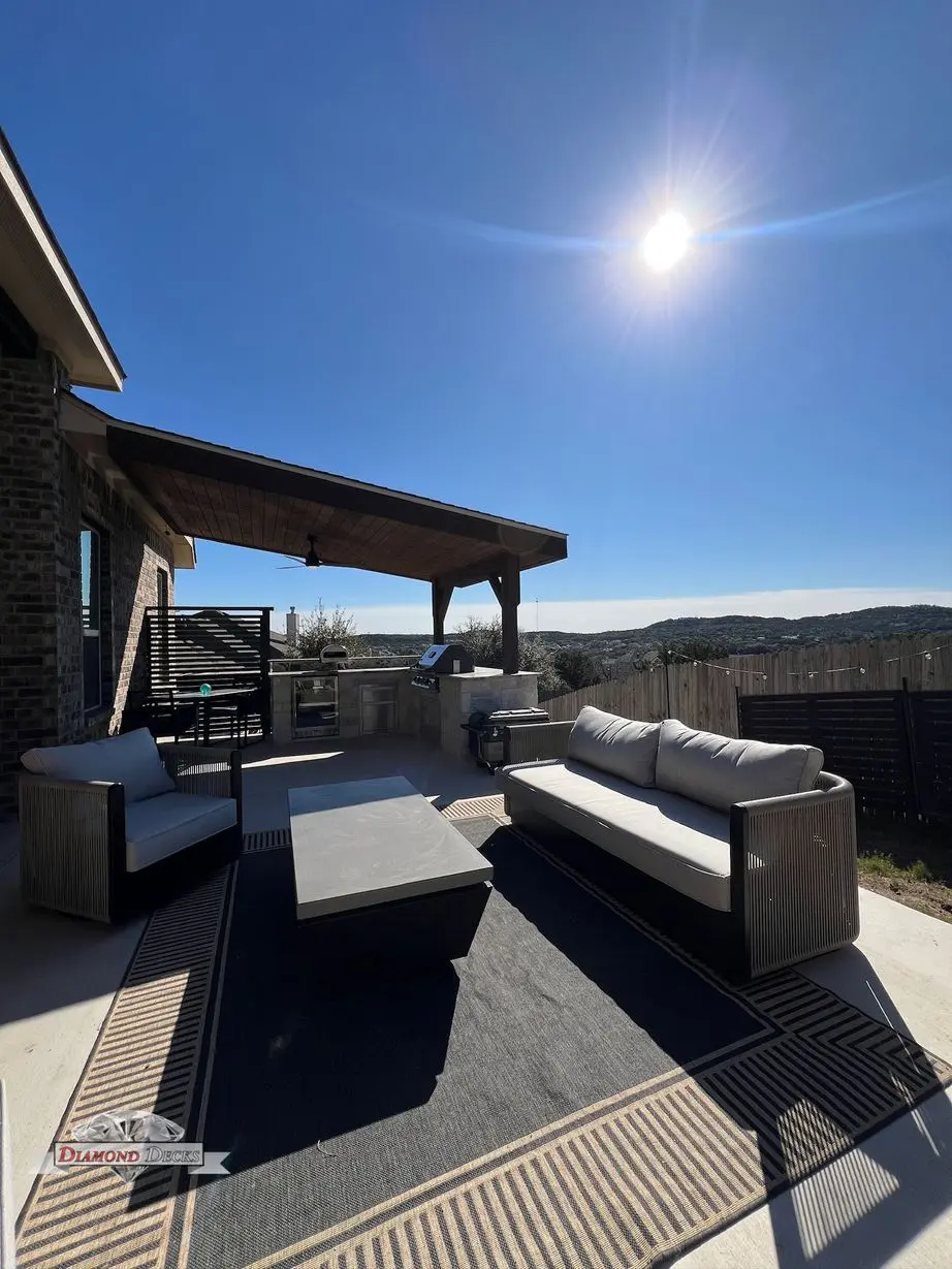 Sunny patio with outdoor kitchen and lounge furniture by Diamond Decks in San Antonio, TX