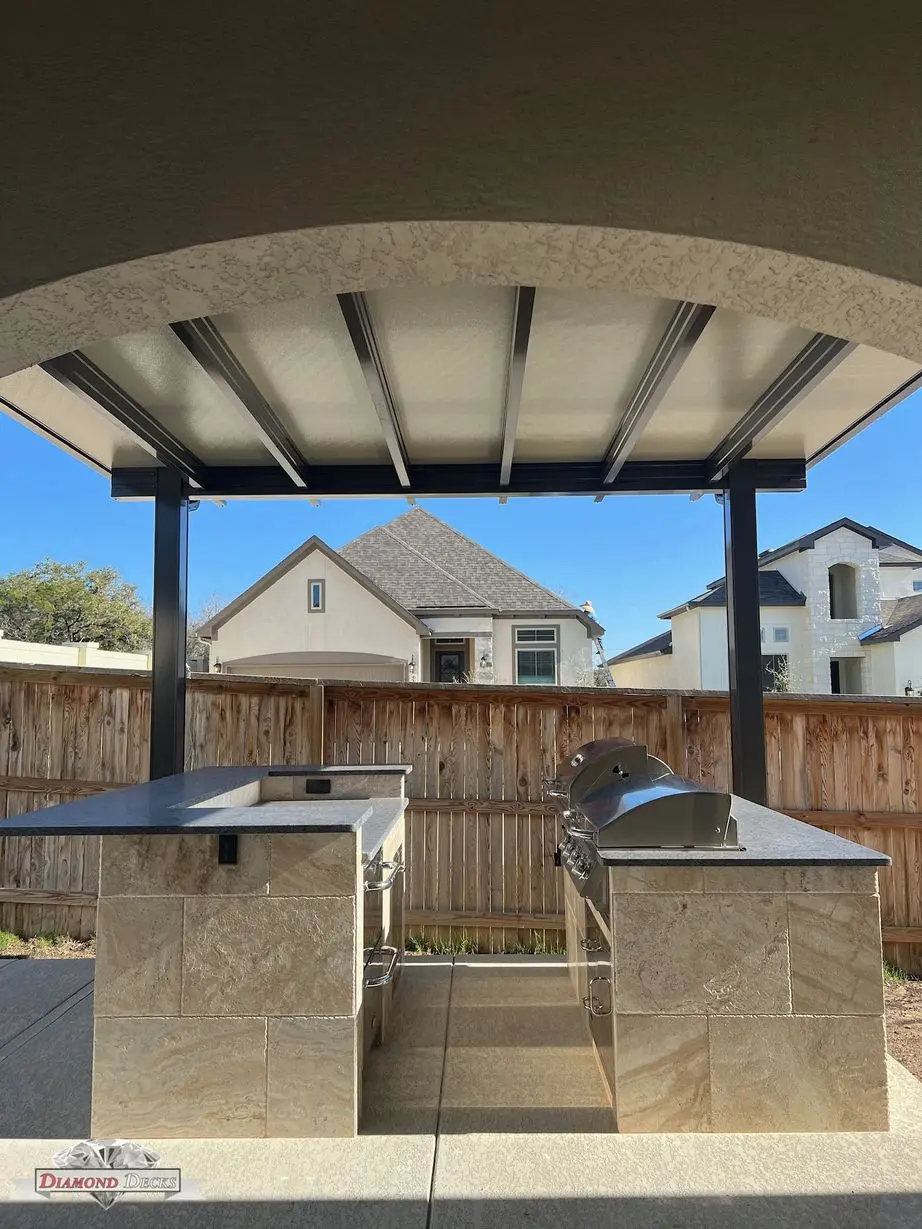 Travertine kitchen islands with dark granite under steel cover by Diamond Decks in San Antonio, TX