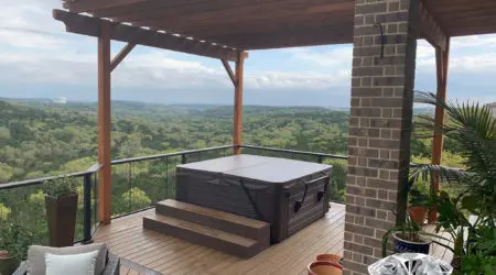 Cedar pergola over composite deck with hot tub and views by Diamond Decks, San Antonio TX