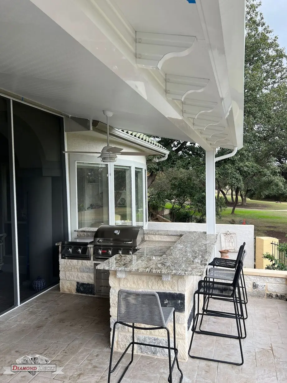 Granite bar with stools under white patio cover by Diamond Decks in San Antonio, TX