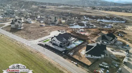 Aerial view of a backyard with dark composite privacy fence and sport court