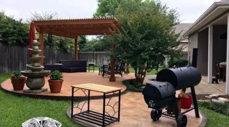 Freestanding cedar pergola on curved composite deck with fountain by Diamond Decks, San Antonio TX