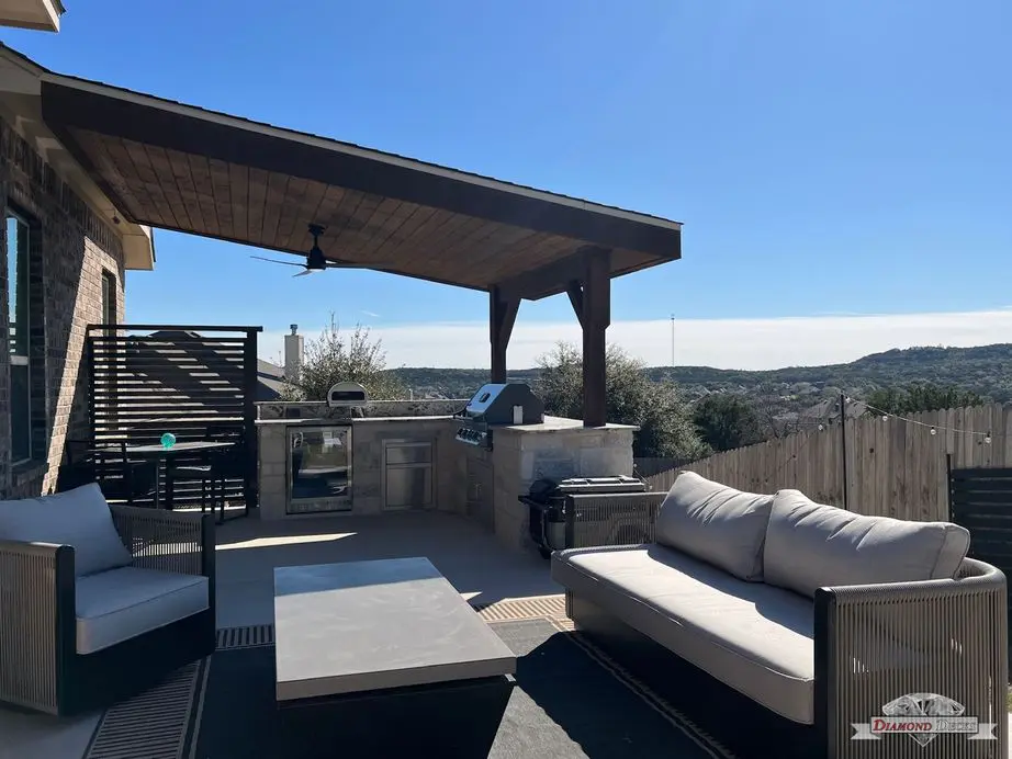 Outdoor living patio with limestone kitchen and pizza oven by Diamond Decks in San Antonio, TX